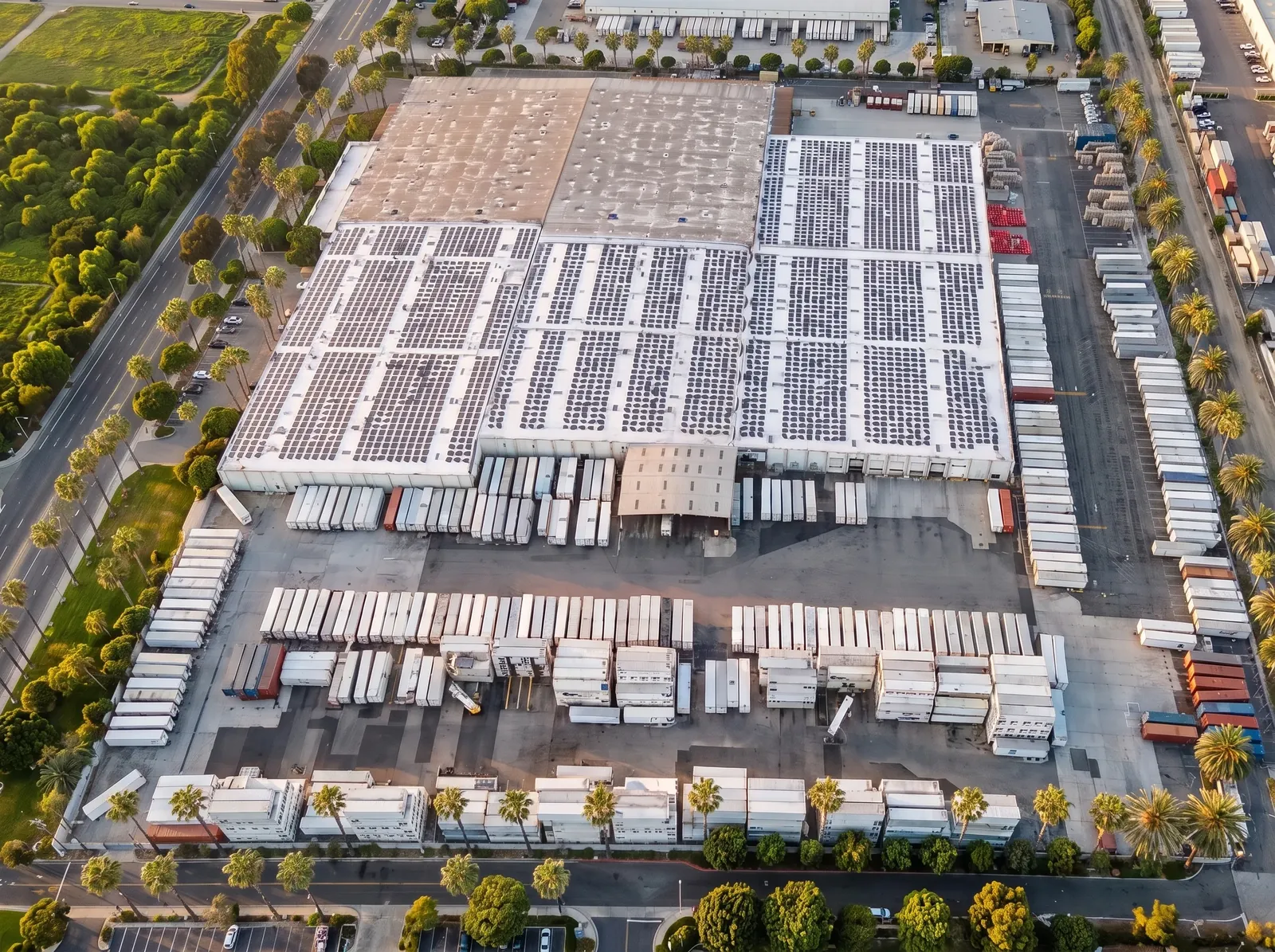 Aerial view of an industrial cold storage facility with a large rooftop solar array