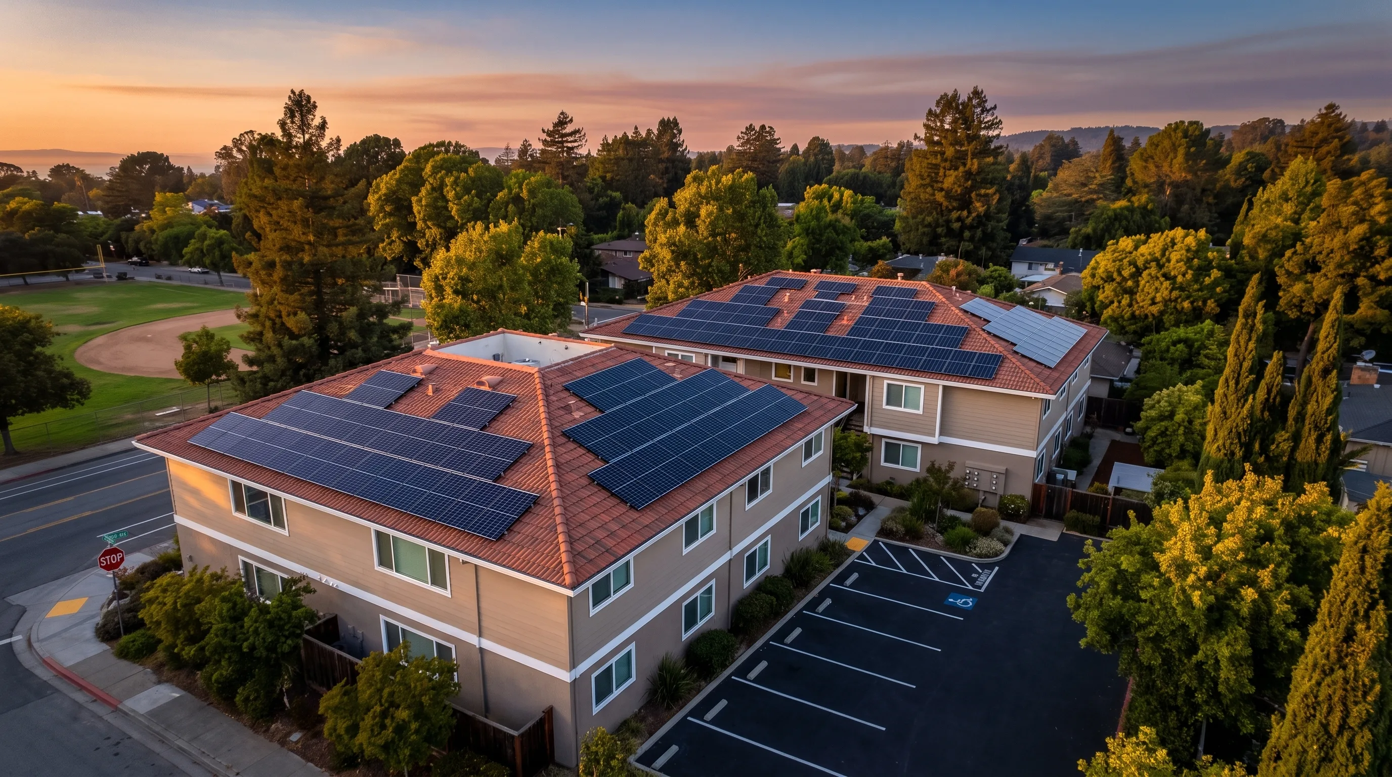 Aerial view of a multifamily apartment building with rooftop solar panels