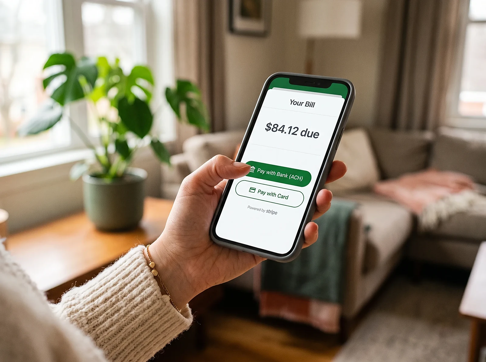 A tenant paying their bill on a smartphone with options to pay by bank transfer or credit card
